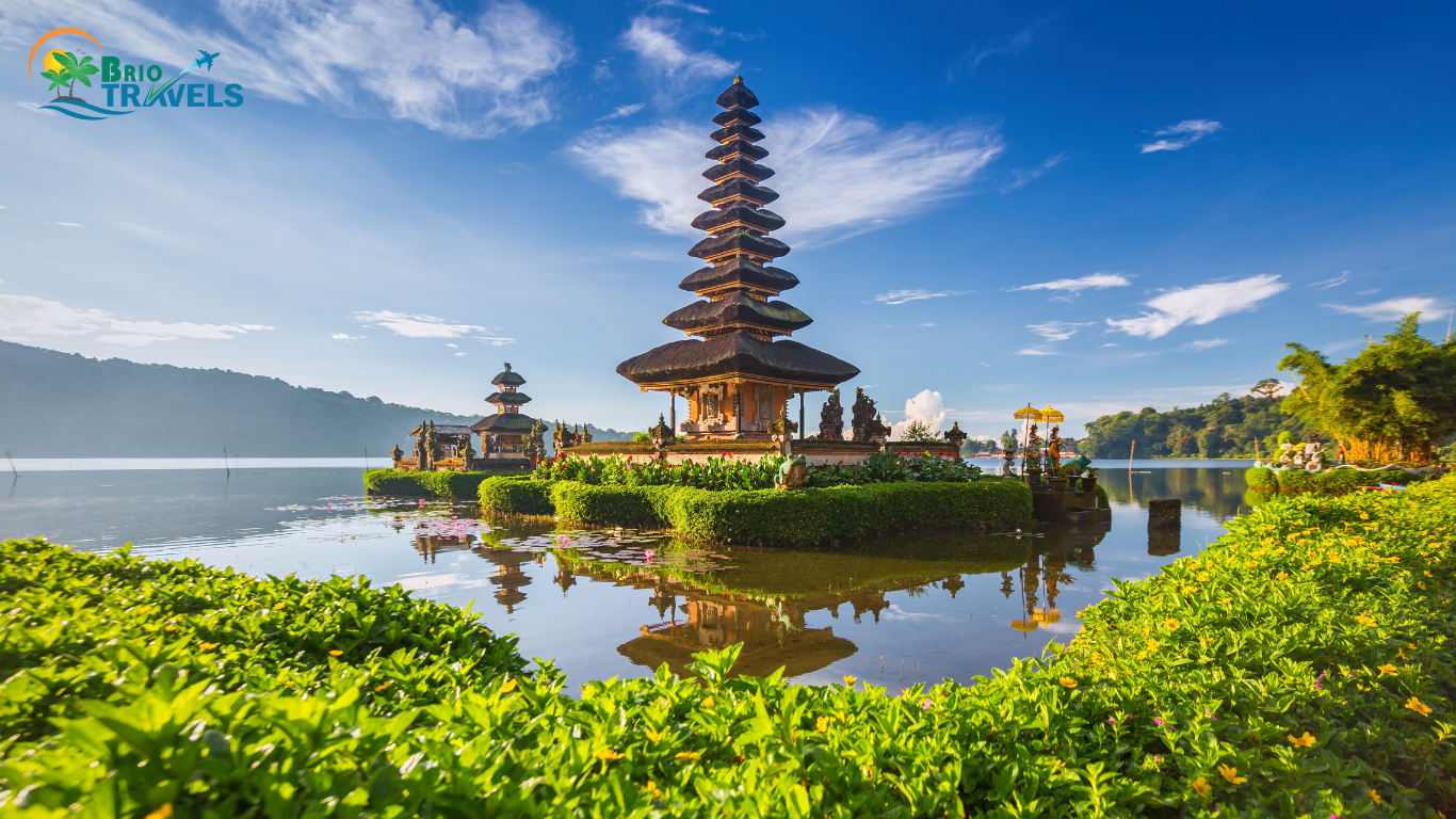 Ulun Danu Beratan Temple in Bali surrounded by a serene lake, vibrant greenery, and a bright blue sky, with the Brio Travels logo displayed in the corner