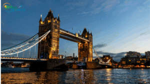 London’s iconic Tower Bridge illuminated at dusk with reflections shimmering on the River Thames, and the Brio Travels logo displayed in the top left corner. International tour package